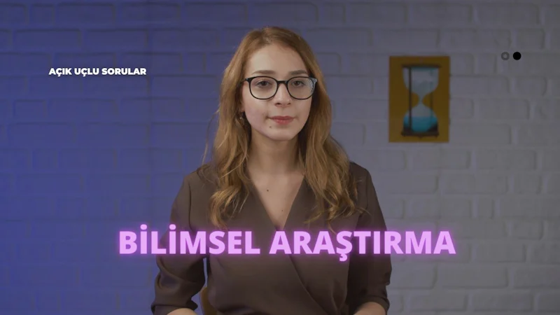 Gözlüklü bir kadın tuğla bir duvarın önünde oturmaktadır. Kahverengi bir gömlek giymiş, uzun saçları sırtından aşağı dökülüyor ve gözleri ileriye bakıyor. Dudakları hafifçe ayrılmış ve dikkati yoğun. Boynu yakın plandan görülebiliyor ve saçları alnını ortaya çıkaracak şekilde geriye çekilmiş. Arka planda bulanık bir kum saati görüntüsü var. Derin düşüncelere dalmış gibi görünüyor. Yüz ifadesi bir tefekkür ve konsantrasyon ifadesi.