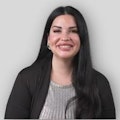 a woman has black hair and holds a silver cardigan as she smiles, in the style of briana mora, dark gray and light beige, webcam, fernando botero, elegantly formal, detailed facial features, weathercore