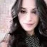 Bu, selfie çeken genç bir kadının fotoğrafı. Başını hafifçe yana eğmiş, dudaklarını hafifçe aralamış ve gözlerini doğrudan objektife dikmiş bir şekilde kameraya bakıyor. Açık mavi bir atlet giymiş ve saçlarını geriye doğru at kuyruğu şeklinde toplamış. Kolunu uzatmış ve fotoğrafı çekmek için telefonunu havaya kaldırıyor. Arka plan bulanık, bu da fotoğrafın iç mekanda çekildiğini gösteriyor. İfadesi kendinden emin ve mutlu, anı yakalamaktan duyduğu sevinci gösteriyor. Etrafı sıcak bir memnuniyet duygusuyla çevrili, bu da onu özel bir anın güzel bir enstantanesi yapıyor.