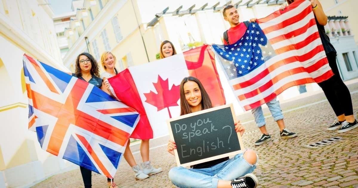 Her biri farklı bir bayrak tutan bir grup insan sıra halinde durmaktadır. Bayrakların renkleri kırmızı ve maviden sarı ve yeşile kadar değişiyor. Sıranın en önünde bir kadın yüzünde bir gülümsemeyle kara tahta tutuyor. Onun arkasında bir adam elinde bir bayrak ve kararlı bir ifadeyle duruyor. Sıranın arkasında, kırmızı beyaz çizgili gömlek giyen bir kişi kameradan uzağa bakarak duruyor. Yan tarafta gözlüklü ve sarı gömlekli bir kadın görülüyor. Arka planda, üzerinde bir gider bulunan tuğladan bir yürüyüş yolu görülüyor. Görüntüdeki tüm insanlar farklı yönlere bakıyor, ancak sergiledikleri bayraklarla bir bütün oluşturuyorlar.