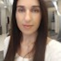 Uzun, dalgalı, siyah saçlı genç bir kadın düz, beyaz bir fonun önünde duruyor. Yüzünde küçük, belli belirsiz bir gülümsemeyle kameradan uzağa bakıyor. Saçları ortadan ayrılmış ve sırtından aşağı dökülüyor. Açık gri bir gömlek ve mavi bir kot pantolon giyiyor ve elleri yanlarında duruyor. Gözleri derin, koyu kahverengi ve teni açık ten rengi. İfadesi sakinlik ve dinginlik hissi veren bir sakinlik ve duruşa sahip. Nazik ve kibar görünüyor ve duruşu rahat ve konforlu. Güzelliği çarpıcı ve uzun saçları yüzünü mükemmel bir şekilde çerçeveliyor. Düz, beyaz arka planda göze çarpıyor ve varlığı büyüleyici.