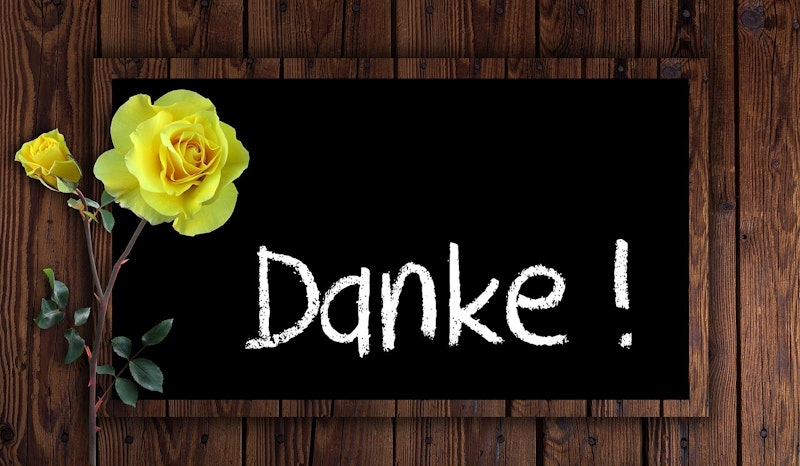 Bu görsel siyah bir tahta üzerine yerleştirilmiş sarı bir gülü tasvir etmektedir. Gülün parlak sarı yaprakları, yeşil yaprakları ve canlı sarı bir merkezi vardır. Tahtanın yüzeyi pürüzsüz ve koyu renkte olup iki nesne arasında keskin bir kontrast yaratmaktadır. Gül resmin ön planında yer alıyor ve çerçevenin büyük bir bölümünü kaplıyor. Yakından çekilmiş olması, yaprakların ve yaprakların karmaşık ayrıntılarının görülmesini sağlıyor. Arka plan bulanıklaştırılarak gülün ana odak noktası olması sağlanmış. Resmin genel kompozisyonu çarpıcı ve büyüleyici.