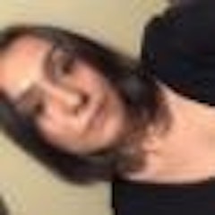 Omuz hizasında siyah saçlı genç bir kadın beyaz bir duvarın önünde selfie çekiyor. Gülümsüyor ve telefonunu iki eliyle yüzünün önünde tutuyor. Telefonu hafifçe aşağı doğru eğilmiş ve ekranın yansımasında gözleri görünüyor. Üç çeyrek kollu beyaz bir üst ve siyah bir etek giymiştir. Makyajı doğal ve dudakları hafif bir gülümsemeyle kıvrılmış. Pozunda kendinden emin ve mutlu görünüyor, selfie'sini göstermeye hazır.