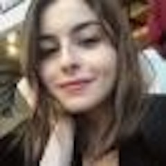 Bu, selfie çeken genç bir kadının görüntüsüdür. Doğal ışık alan aydınlık bir odada duruyor, yüzü güneş tarafından aydınlatılmış. Kahverengi saçları at kuyruğu şeklinde toplanmış ve mavi bir tişört giyiyor. Akıllı telefonunu sağ elinde tutuyor, kolunu uzatmış ve fotoğrafı çekerken ekrana bakıyor. Sol elini hafifçe çenesine koymuş, sanki çekim için en iyi açıyı düşünüyormuş gibi. Yüzünde kendinden emin, mutlu bir ifade var ve gözleri telefonuna odaklanmış durumda. Kendine ait bir anıyı yakalamak için bir an ayırıyor ve bu selfie harika bir selfie olacak gibi görünüyor.