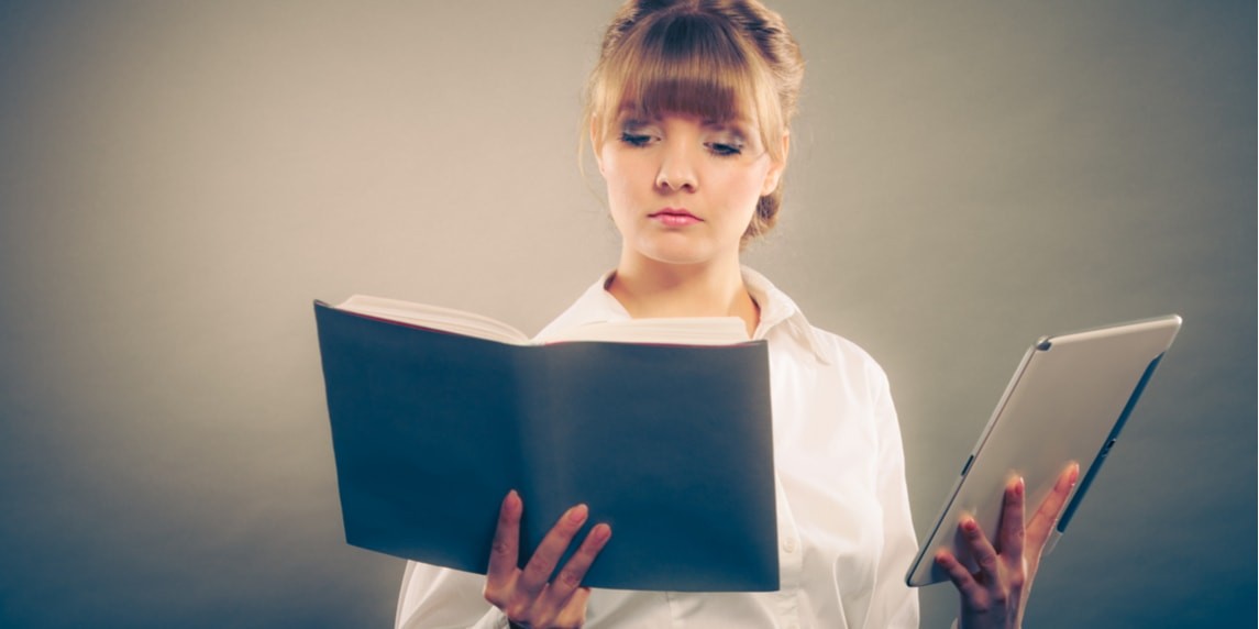 Genç bir kadın beyaz bir fonun önünde durmakta, sol elinde bir kitap, sağ elinde ise bir cep telefonu tutmaktadır. Gözleri sayfalara odaklanmış bir şekilde kitaba bakıyor. Sarı saçları arkaya doğru düşük bir at kuyruğu şeklinde toplanmış ve üzerinde yüksek yakalı siyah bir bluz var. Kitap elinde açık ve telefonu da ona yakın tutuyor. Telefon siyah ekranlı, modern ve ince bir tasarıma sahip. Duruşu rahattır, kolları dirseklerinden hafifçe bükülmüş, elleri ve kolları rahat ve gevşek bir şekilde konumlandırılmıştır. Yüz ifadesi huzurlu ve memnun.
