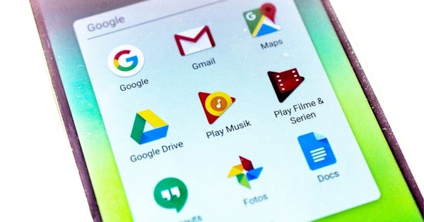 Bu, modern bir dokunmatik ekranlı akıllı telefonun yakından çekilmiş bir görüntüsüdür. Telefon açık ve ekran parlak bir şekilde aydınlatılmış. Ana ekranda satırlar ve sütunlar halinde düzgünce düzenlenmiş çok sayıda renkli uygulama simgesi görüntülenmektedir. Telefonun duvar kağıdı açık mavi ızgara desenli beyazdır. Ekranın üst kısmı hafifçe yuvarlatılmıştır ve telefon bir el tarafından tutulmaktadır. Güç düğmesi ve ses kontrolü de dahil olmak üzere telefonun yanlarındaki düğmeler görülebilir. Telefonun kenarları keskin ve telefon şık ve modern görünüyor.