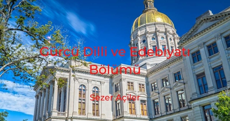 Bu görüntü, üzerinde altın bir kubbe bulunan büyük bir binayı gösteriyor. Kubbe yansıtıcı bir malzemeden yapılmış ve güneş ışığı ondan yansıyarak parlak ve sıcak bir atmosfer yaratıyor. Binanın kendisi beyazdır ve gökyüzüne karşı duran uzun bir kulesi vardır. Binanın yan tarafında kırmızı bir harf ve arka planda birkaç ağaç var. En yakın ağacın yeşil yaprakları var ve görüntünün ön planında yer alıyor. Görüntünün büyük bir kısmı binanın yakın çekimidir ve mimarisinin karmaşık ayrıntılarını göstermektedir. Altın kubbe gökyüzüne karşı öne çıkıyor ve görüntüye görkemli ve muhteşem bir hava katıyor.