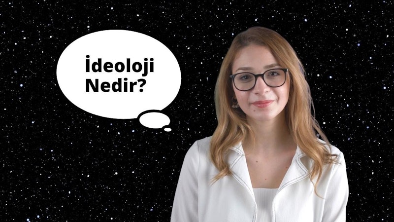 Gözlüklü ve beyaz gömlekli bir kadın beyaz bir arka planın önünde duruyor. Yüzünde ciddi bir ifadeyle dosdoğru ileriye bakıyor. Gözlükleri kahverengi gözlerini çerçeveliyor ve koyu kahverengi saçları topuz yapılmış. Gömleği sade ve süssüzdür ve takı takmamıştır. Elleri iki yanında, dik ve kendinden emin bir duruşu var. Görüntüdeki ışık parlak ve eşit, doğal ve dengeli bir görünüm yaratıyor. Kadın sakin ve soğukkanlı bir hisle çevrelenmiştir.