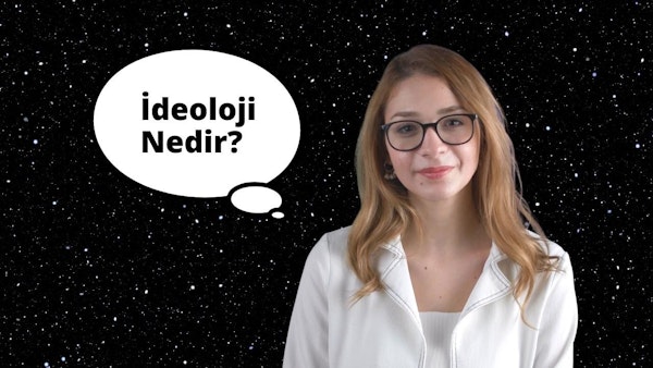 Gözlüklü ve beyaz gömlekli bir kadın beyaz bir arka planın önünde duruyor. Yüzünde ciddi bir ifadeyle dosdoğru ileriye bakıyor. Gözlükleri kahverengi gözlerini çerçeveliyor ve koyu kahverengi saçları topuz yapılmış. Gömleği sade ve süssüzdür ve takı takmamıştır. Elleri iki yanında, dik ve kendinden emin bir duruşu var. Görüntüdeki ışık parlak ve eşit, doğal ve dengeli bir görünüm yaratıyor. Kadın sakin ve soğukkanlı bir hisle çevrelenmiştir.