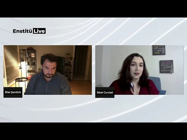 Bir erkek ve kadın mavi bir sandalyede oturmaktadır. Adamın sakalı ve bıyığı vardır ve mavi bir gömlek giymektedir. Kadının uzun saçları var ve bacak bacak üstüne atmış oturuyor. Her ikisinin de kolları sandalyenin kolçaklarına dayanmış. Adam kadına hayranlıkla bakarken yüzünde sıcak bir gülümseme var. Kadın başını hafifçe sola eğmiş ve sevgi dolu bir ifadeyle adama bakıyor. Her ikisi de paylaştıkları anın tadını çıkarıyor, birbirlerinin arkadaşlığından memnun görünüyorlar.