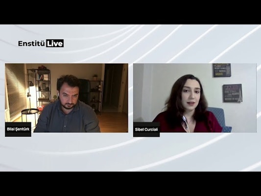 Bir erkek ve kadın mavi bir sandalyede oturmaktadır. Adamın sakalı ve bıyığı vardır ve mavi bir gömlek giymektedir. Kadının uzun saçları var ve bacak bacak üstüne atmış oturuyor. Her ikisinin de kolları sandalyenin kolçaklarına dayanmış. Adam kadına hayranlıkla bakarken yüzünde sıcak bir gülümseme var. Kadın başını hafifçe sola eğmiş ve sevgi dolu bir ifadeyle adama bakıyor. Her ikisi de paylaştıkları anın tadını çıkarıyor, birbirlerinin arkadaşlığından memnun görünüyorlar.