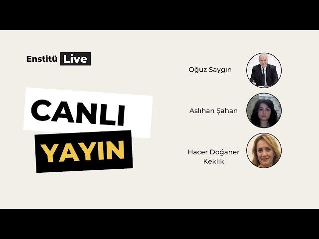 Bir grup insan bir odada daire şeklinde toplanmıştır. Çemberin ortasında takım elbise giymiş bir adam göze çarpmaktadır. Ciddi bir ifadeyle kameradan uzağa bakmaktadır. Adamın solunda bir kadın kameraya gülümsemektedir. Koyu renk saçları var ve açık renkli bir elbise giyiyor. Adamın sağında, kollarını kavuşturmuş bir başka kadın duruyor. O da koyu renk saçlı ve kameradan uzağa bakıyor gibi görünüyor.