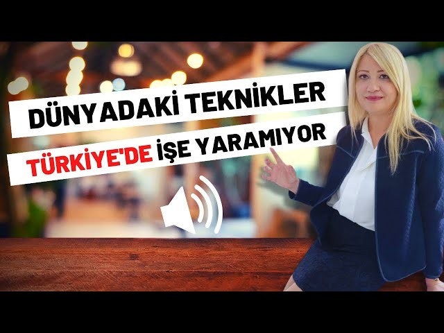 Mavi takım elbiseli bir kadın iyi aydınlatılmış bir alanda bir bankta oturmaktadır. Sarı saçları yana doğru taranmıştır ve açık mavi bir etek ile ona uygun bir takım elbise ceketi giymektedir. Yanındaki bankta üzerinde dalgalar olan beyaz bir hoparlör sembolü vardır. Sağında üzerinde siyah yazılar olan bir tabela vardır. Arka planda ahşap bir yüzeyin yakın çekimi var. Kadın yüzünde huzurlu bir ifadeyle uzaklara bakmaktadır. Beyaz bir gömlek giymiş ve kollarını bankın üzerine dayamış.