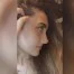 Bu bir kadının yüzünün yakın çekim fotoğrafı. Sıcak, pembe bir alt tona sahip açık tenli görünüyor. Gözleri badem şeklinde ve kaşları ince ve zarif bir şekilde kemerli. Dudakları dolgun ve dolgun ve burnu küçük, düğme benzeri bir şekle sahip. Sağ yanağında, burnunun yanında bir güzellik izi vardır. İfadesi nazik ve huzurlu, bir parça da memnuniyet içeriyor. Çenesinde küçük bir gamzesi vardır ve saçları yüzünden geriye doğru taranmıştır. Öne çıkan ve parlayan çok doğal, klasik bir güzelliği var.