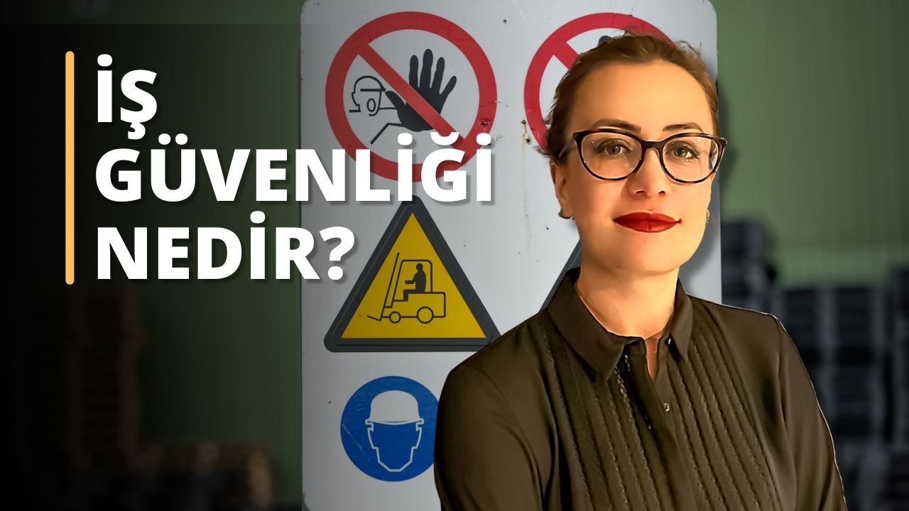 Gözlüklü bir kadın, üzerinde forklift bulunan sarı üçgen bir tabelanın önünde durmaktadır. Siyah bir gömlek giymiş ve ellerini iki yana açmış. Gözlükleri ışığı yansıtarak gözlerini görünür kılmaktadır. Arka planda, üzerinde yüz maskesi olan mavi beyaz bir tabelanın yanı sıra bir el ve kırmızı bir daire olan bir tabela var. Kadın dümdüz karşıya bakıyor ve gözlerinin yakın çekimi görülebiliyor. Forklift görüntünün ortasındadır ve sarı üçgen bir uyarı işaretidir. Kadının duruşu kendinden emin ve kontrolü elinde tutuyor gibi görünüyor.