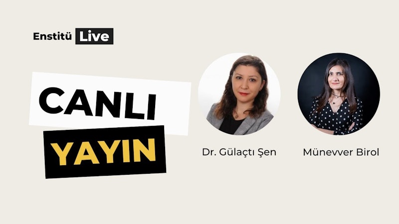 Bu görüntü aydınlık bir odada dört kişilik bir grubu gösteriyor. Ana özne, gri bir blazer ceket ve siyah beyaz puantiyeli bir gömlek giyen uzun, koyu renk saçlı bir kadın. Kollarını önünde kavuşturmuş. Solunda uzun saçlı, beyaz gömlek ve mavi kot pantolon giymiş başka bir kadın var. Onun yanında mavi gömlek ve gri pantolon giyen kısa saçlı bir adam var. Son olarak, ana öznenin sağında siyah ceket ve beyaz gömlek giyen kel kafalı bir adam var. Dört kişi de farklı yönlere bakıyor ve görüntüye bir enerji ve hareket hissi veriyor.