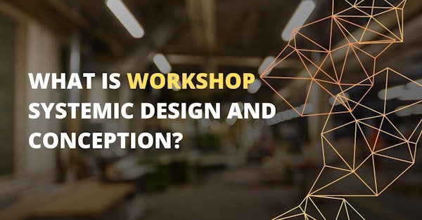 This close-up image shows a workshop, with a logo in the background on the right side. The logo is a white text on a black background, and there is a light on the ceiling as well. There is also a yellow letter on a black background in the lower middle of the image. In the foreground, there is a triangle in focus, and a blurry image of a person's hand just to the left. The room has a window and a sign in the background, and the overall image is slightly out of focus.