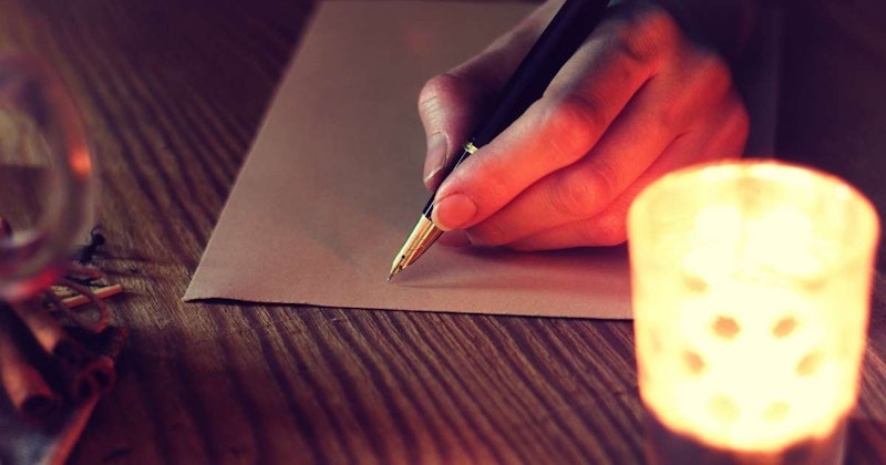 Parmakları kalemin gövdesine sarılmış siyah bir kalem tutan bir el görülüyor. Kalem çerçevenin ortasına yerleştirilmiş, el ise ön planda görülüyor. El sanki bir kağıda yazıyormuş gibi uzanıyor. Elin tırnakları hafifçe görünüyor ve elin ten rengi açık bir tonda. Görüntünün arka planı odak dışıdır ve beyaz bir duvar olarak görülebilir. Kalemin kendisi parlak bir yüzeye sahip ve bir tükenmez kalem gibi görünüyor. El sabittir ve kalemi sıkıca kavramıştır.