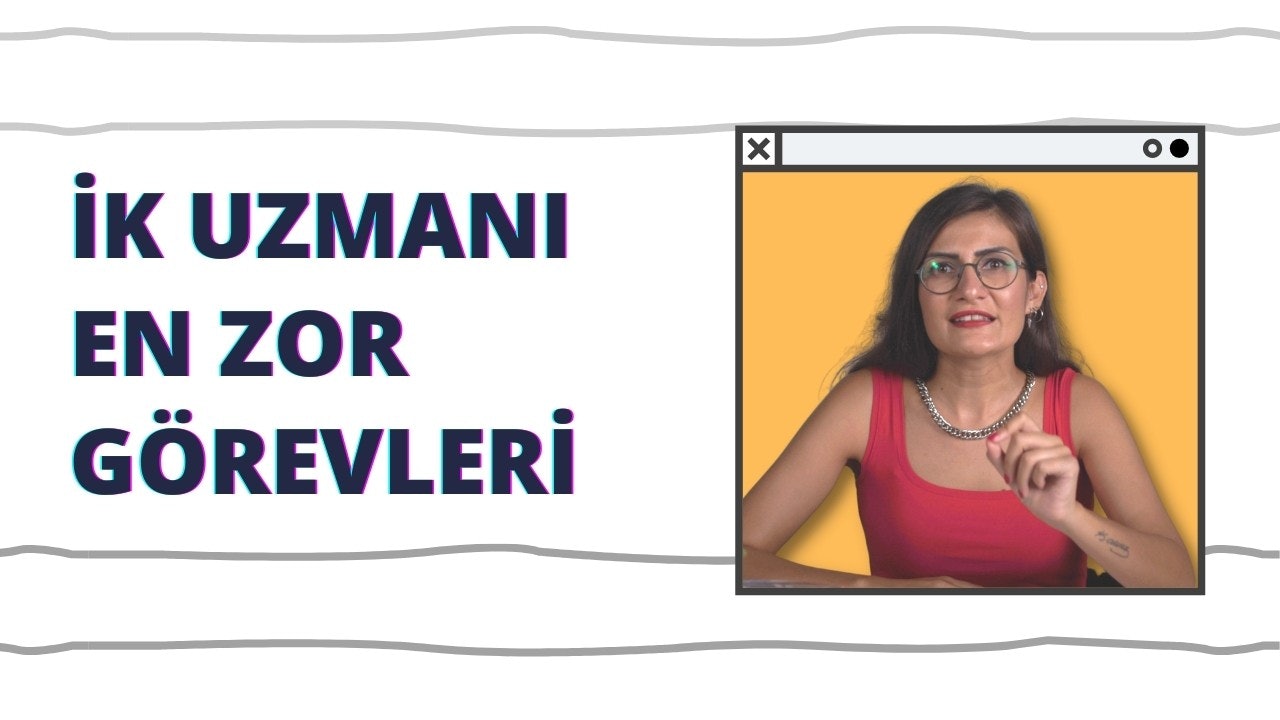 Kırmızı atletli ve gözlüklü bir kadın beyaz bir arka plan üzerinde durmaktadır. Doğrudan kameraya bakmaktadır ve boynunda bir kolye vardır. Gözleri odaklanmıştır ve dudakları hafifçe ayrılmıştır. Atletinin üzerinde siyah ve mavi harfler vardır. Ciddi bir ifadesi var ve derin düşüncelere dalmış gibi görünüyor. Kolye yakından çekilmiş ve üzerinde küçük yuvarlak bir kolye ucu var. Atletinin kırmızısı beyaz fonda göze çarpıyor ve gözlükleri yüzünü çerçeveliyor.