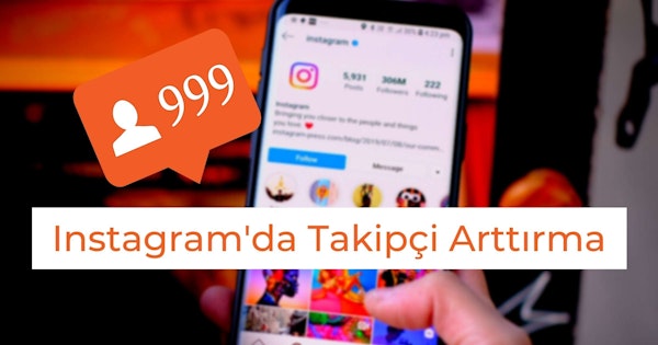Renkli bir daireden oluşan bir logo gösteren parlak bir ekranı olan bir cep telefonu tutan bir elin yakın çekimi. Görüntünün sol üst köşesinde, üzerinde beyaz metin ve rakamlar bulunan bulanık turuncu dikdörtgen bir işaret görülüyor. Ortada bir parmak bir resmi işaret etmektedir. Görüntünün sağ alt köşesinde dairesel şekilli bir logo görülüyor. Arka planda, bir kişinin gölgesinin bulanık bir görüntüsü görülebiliyor.