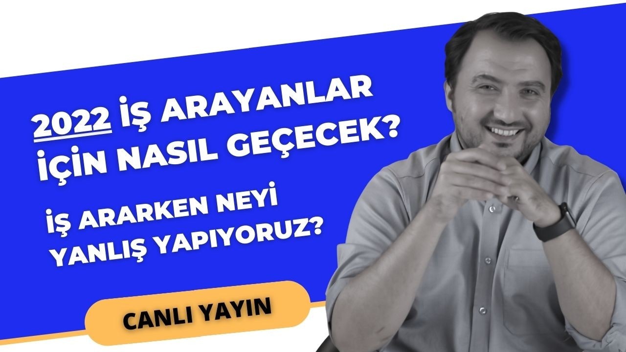 Bir adam, üzerinde beyaz yazılar olan mavi bir tabelanın önünde duruyor. Gülümsüyor ve sağ eli ağzının önündeyken sol elinde bir mikrofon tutuyor. Adamın yüzü yakın plandadır ve sol bileğinde siyah bir bant takılıdır. Gömleğinin yakasında da yakın çekimde bir düğme vardır. Burnu da yakın plandadır ve gülümsemesinden dolayı hafifçe kırışmıştır. Kendinden emin ve rahat görünüyor ve gözleri kameraya dönük.