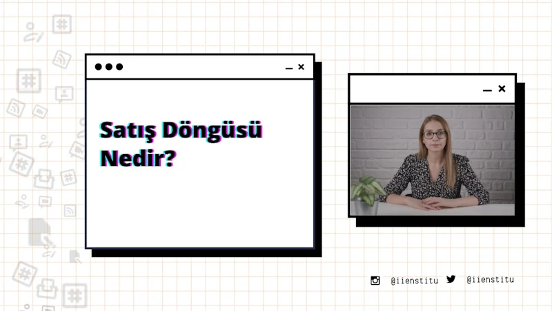 Bir kadın modern bir ofiste masasında oturuyor. Kollarını kavuşturmuş ve dümdüz ileriye bakıyor. Uzun, koyu renk saçları var ve siyah-mor bir gömlek giyiyor. Masanın üzerinde bir bilgisayar ve arka planda bir cep telefonunun ekran görüntüsü var. Sağında, her ikisi de hafifçe odak dışında kalan bir sebze ve bir bitki var. Solunda, üzerinde siyah ve kırmızı çizgiler olan beyaz bir kare ve bir bitkinin bulanık bir görüntüsü var.