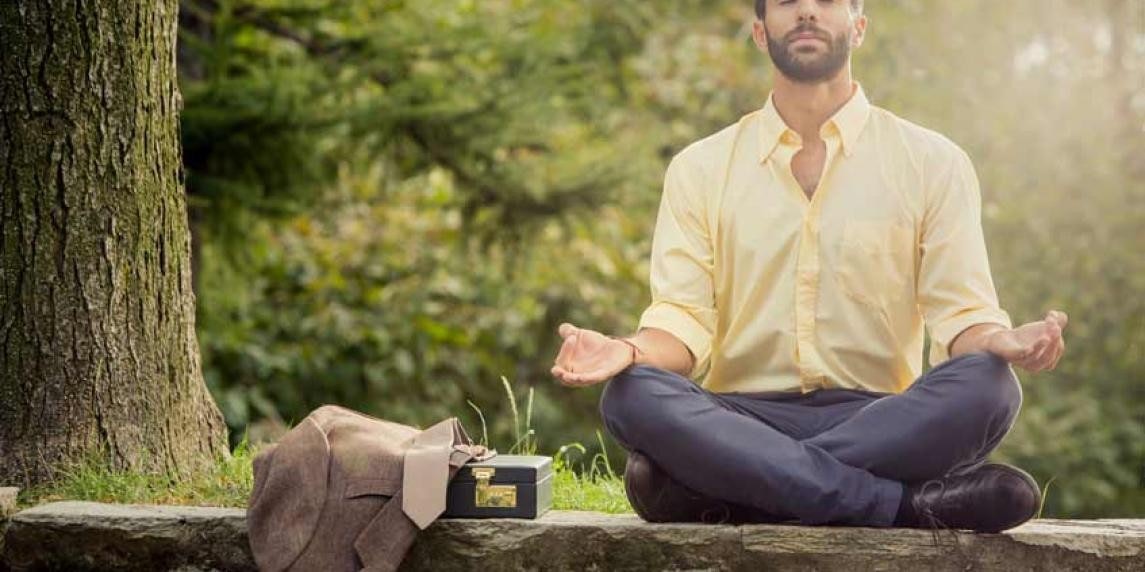 Bir adam parktaki bir taş çıkıntının üzerinde huzurlu bir lotus pozunda oturuyor. Üzerinde sarı bir gömlek var ve meditasyon yaparken gözleri kapalı. Etrafında bir ağaç gövdesi, bir taş basamak ve duvarda beyaz bir havlu var. Güneş parlıyor ve gökyüzü açık. Takım elbisesinin ve yanındaki kutunun yakın çekimi var. Adam hareketsiz, kollarını kavuşturmuş ve bacak bacak üstüne atmış, sakin ve rahat bir duruşta oturmaktadır. Yüzü sakin, nefes alış verişi düzenli. Kendisiyle ve çevresiyle tamamen barışıktır. Ortam dingindir ve adam iç huzuru içindedir.