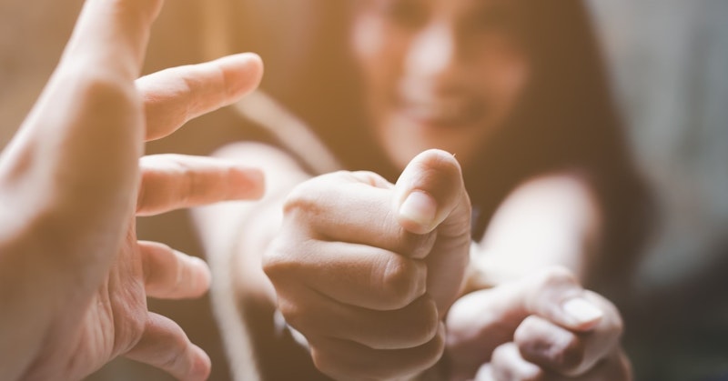 Görüntüde kameraya doğru bakan bir elin yakın çekimi görülüyor. Tırnak açıkça görülebiliyor ve parmak dışa doğru işaret ediyor. Elin derisi pürüzsüz ve narindir ve parmak hafifçe kavislidir. Arka planda bir kişinin yüzü görülüyor ve ifade kararlı ve odaklanmış. El, izleyiciye meydan okur gibi otoriter bir jestle tutulmuştur. Işık parlak ve eşit, renkler ise canlı. Tüm sahne büyüleyici ve ilgi çekici, güç ve kuvvet hissi uyandırıyor.