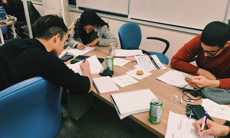 Bir grup insan, siyah kolçaklı mavi bir sandalye ve arkasında kağıtlar olan büyük bir masanın etrafında oturuyor. Bir kadın bir kâğıda bir şeyler yazarken bir adam cep telefonuna bakmaktadır. Masanın üzerinde beyaz etiketli yeşil bir kutu ve bir defter var. Yakınlarda, spiralli bir defter masanın üzerinde durmakta ve bir kağıt parçasının yakın çekimi görülmektedir. Son olarak, bir adam bir kâğıt parçasına bir şeyler yazmaktadır ve yüzü yapacağı işe odaklanmıştır. Hepsi birlikte çalışarak bir işbirliği ve bağlantı sahnesi yaratıyor.