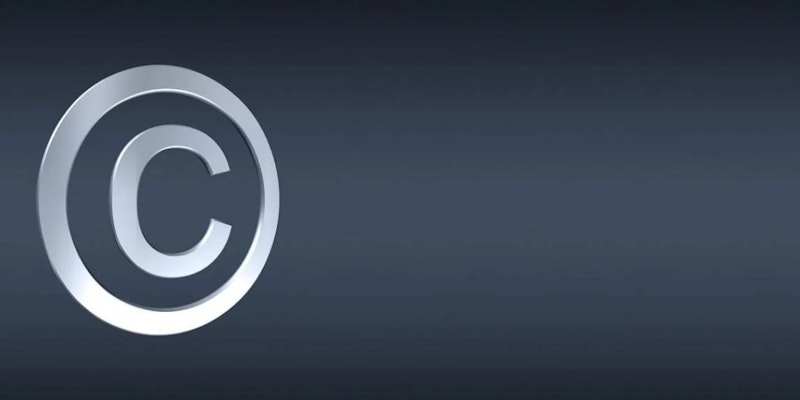 Bu görüntü, siyah zemin üzerinde bir telif hakkı sembolünün yakın çekimini göstermektedir. Sembol beyaz renklidir ve köşelerinde kavisler bulunan dikdörtgen bir şekle sahiptir. Sembolün içinde, biri diğerinin üzerinde olmak üzere iki adet c şeklinde çizgi bulunmaktadır. Arka planda beyaz çizgilerle mavi bir arka plan var ve sembolün kenarları hafifçe bulanık. Sembol görüntünün ortasına yerleştirilmiştir ve sembolün genişliği 361 piksel ve yüksekliği 397 pikseldir. Genel görüntü genişliği 1145 piksel ve yüksekliği 572 pikseldir.