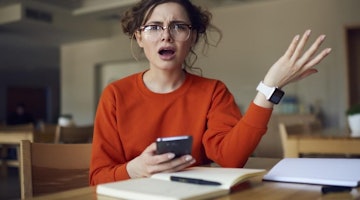 Bu görüntü gözlük ve saat takmış, elinde telefon tutan bir kadının yakın çekimidir. Gözleri kısmen kapalı bir şekilde sağa doğru bakmaktadır. Sol eli yukarı kalkmış ve telefonu sanki telefonla konuşuyormuş gibi kulağına doğru tutmaktadır. Bileğinde siyah bir saat var ve gözlüklerinin çerçevesi siyah. Arka planda beyaz bir saksı bitkisi, beyaz bir yüzey ve bir kişinin elinin bulanık bir görüntüsü var. Ayrıca beyaz bir kağıt üzerinde bir resim, bir saat ve bir kalemin yakın çekimi vardır.