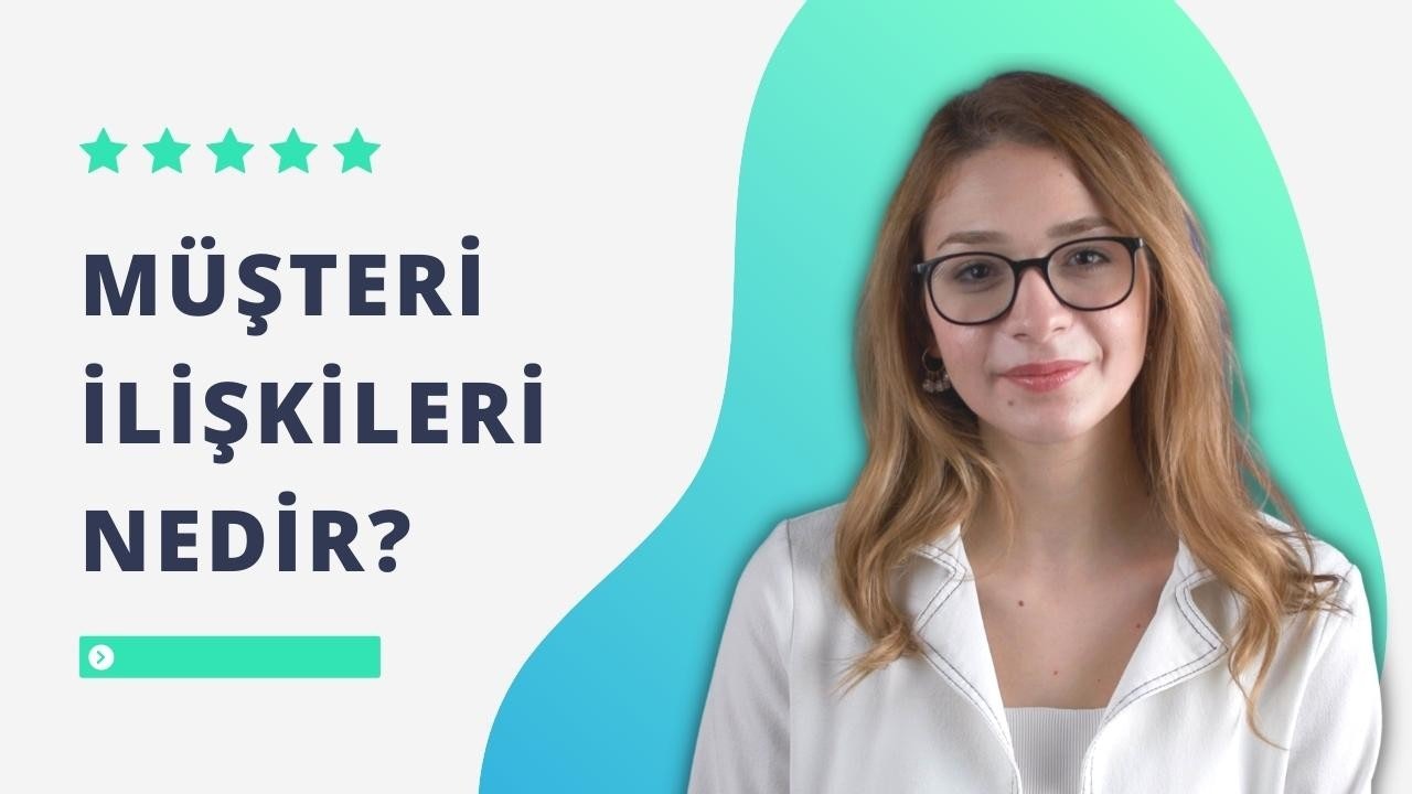 Bu, gözlüklü ve beyaz gömlekli, büyük ve mutlu bir gülümsemeye sahip genç bir kadının yakın plan görüntüsüdür. Gözlüklerinin vurguladığı parlak gözleriyle doğrudan kameraya bakıyor. Saçları uzun ve koyu renk, yüzünü çerçeveliyor. Dudakları hafifçe ayrılmış ve dişleri görülebiliyor. Yanaklarında sağlıklı bir parıltı var ve gözleri neşe dolu. Kıyafetine şıklık katan bir kolye takıyor. Gözlükler klasik bir şekle sahip, siyah çerçeveli ve şeffaf camlı. Arka plan bulanıklaştırılarak odak noktasının kadın üzerinde kalması sağlanmış.