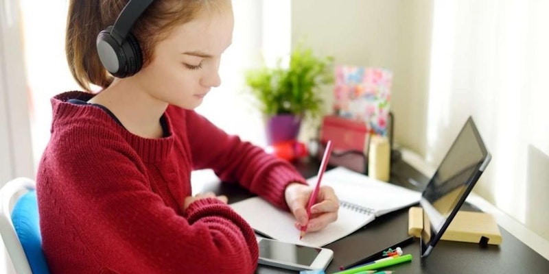 Kulaklık takmış genç bir kız masanın üzerindeki deftere bakarak dikkatle bir şeyler yazmaktadır. Üzerinde koyu renkli bir kazak var ve sarı saçları yüzünden geriye doğru toplanmış. Defter beyaz bir sayfaya açılmıştır ve sağ elinde siyah bir kalem vardır. Altında kırmızı bir zemin olan aydınlık bir odada oturmaktadır. Arkasında pembe bir duvar ve yerde mavi bir yastık vardır. Yakınında bir kulaklık durmaktadır. Görüntü bulanık, ancak kızın yüzünün ve defterinin ayrıntıları odakta.