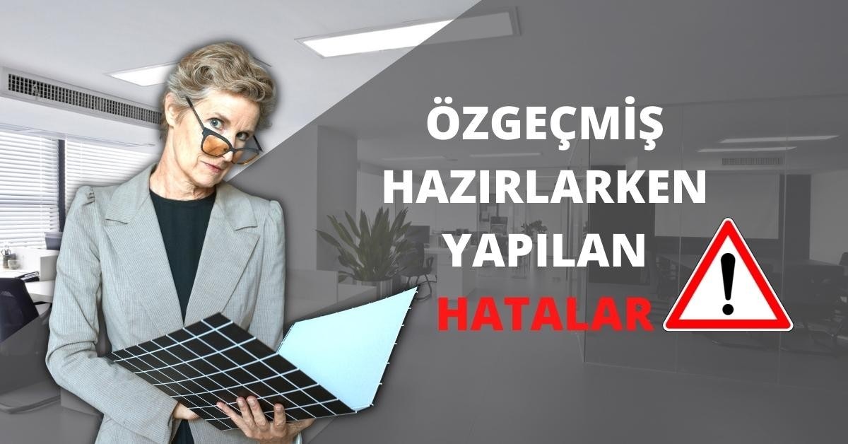 Gözlüklü bir kadın elinde bir dosya tutuyor. Kısa saçları var ve elindeki nesneye bakıyor. Sağ elinde, üzerinde küçük karelerden oluşan bir desen bulunan siyah beyaz bir klasör tutmaktadır. Arka planda, köşede saksıda bir bitki ve görüntünün sağ tarafında üzerinde siyah bir ünlem işareti bulunan kırmızı beyaz bir üçgen işareti görülüyor. Sol tarafta, bir takım elbisenin yakın çekimi ve görüntünün üst köşesinde gri ve beyaz bir logo görülüyor. Görüntünün ortasında metin içeren bir işaretin yakın çekimi de görülebilir.