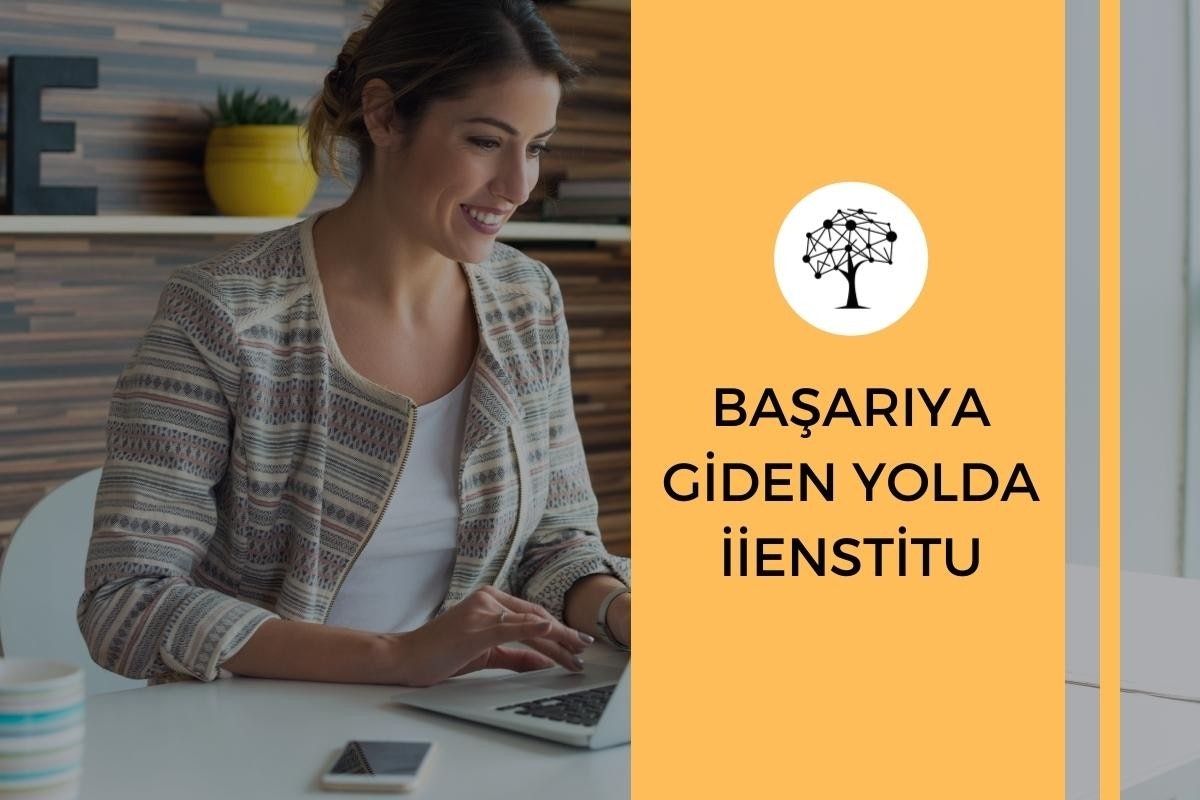 Genç bir kadın masa başında oturmuş, dizüstü bilgisayarına bakarken gülümsüyor. Uzun açık kahverengi saçları yüzünden geriye doğru toplanmış. Üzerinde beyaz düğmeli bir gömlek var ve elleri dizüstü bilgisayarın klavyesinde. Arkasında, içinde yeşil bir bitki olan sarı bir saksı görülüyor. Görüntünün en sağ tarafında bulanık mavi ve beyaz çizgili bir nesne var. Resmin alt kısmında, ön planda bir eli dizüstü bilgisayarın üzerinde olan bir kişinin kafasının yakın çekimi yer alıyor. Kişinin dikey çizgili bir desene sahip gömleği de görüntüde görülebiliyor.