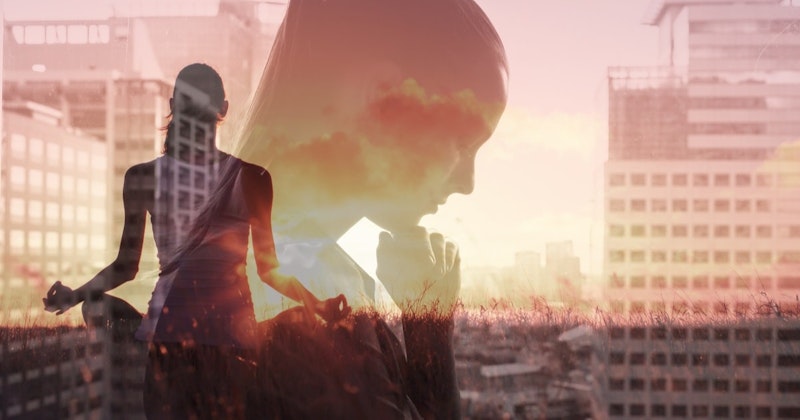 Uzun siyah saçlı genç bir kadın yere oturmuş, elini çenesinin altına dayamış. Siyah desenli açık sarı bir elbise giymiş ve derin düşüncelere dalmış gibi görünüyor. Gözleri kapalı ve dudakları hafifçe büzülmüş. Kolları yoga pozunda ve bacak bacak üstüne atmış. Etrafı yeşil çimenlerle çevrili ve arka planda bulanık bir bina görüntüsü var. Huzurlu ve rahat görünüyor, yüzünde hafif bir gülümseme var.