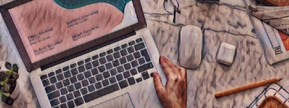This image shows a close-up of an open laptop, with a human hand resting on the keyboard. The laptop is a sleek, silver model, with a black keyboard and trackpad. The hand is shown in mid-air, with the fingers slightly curved inwards, as if typing on the keys. The wrist is supported by the edge of the laptop, suggesting that the person is concentrating on their work. The background is a well-lit room, with a few plants and a wooden table visible. The overall feeling of the image is one of productivity and concentration.