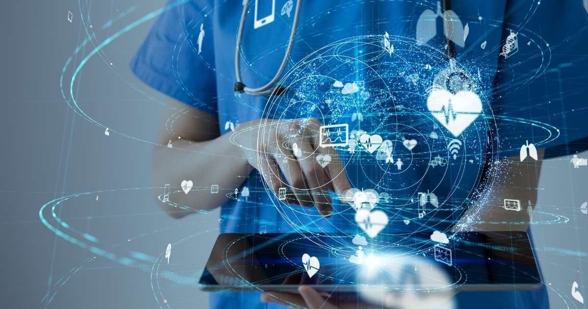 Bu görüntüde beyaz önlük giymiş bir doktor tablet kullanırken resmedilmiştir. Tablet iki eliyle tutulmakta ve doktorun başparmakları ekranın üzerinde durmaktadır. Sol üst köşede mavi bir arka plan üzerinde duran bir stetoskop görülebiliyor. Doktorun yüzü, görüntünün sağında gökyüzündeki parlak bir ışıkla aydınlatılmış. Doktor, ekranı kaydırmak veya ekrana dokunmak gibi bir tür dijital faaliyette bulunuyor gibi görünüyor. Doktor cihaz üzerinde çalışırken sahne bir odaklanma ve konsantrasyon hissiyle doludur. Sahne aynı zamanda, doktorun mekânda yalnız olması ve arka plandaki parlak gökyüzü ile sakin ve huzurlu bir his uyandırıyor.