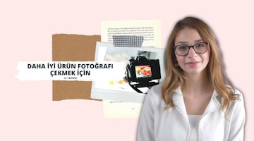 Beyaz ceketli bir kadın bir odada durmaktadır. Gözlük takıyor ve saçlarını şekillendirmiş. Üzerinde ekran olan bir fotoğraf makinesiyle fotoğraf çekmektedir. Ön planda siyah ve beyaz karelerden oluşan ızgara desenli bir kağıt parçası var. Yakından bakıldığında gözleri ve dudakları görülebiliyor. Elini kaldırmış, önündeki yiyeceğin fotoğrafını çekmeye hazır. Yakın planda göğsü, beyaz gömleği ve kolyesi görünüyor. Kararlı ve görevine odaklanmış görünüyor.