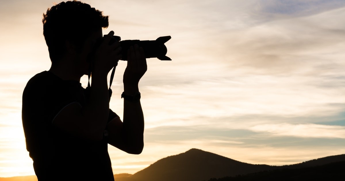 Ön planda, önünde bir kamera tutan bir insan silueti görülüyor. Arka planda yine siluet halinde bir dağ var. Kişi fotoğraf makinesinin vizöründen bakıyor ve muhtemelen bir fotoğraf çekiyor. Kişi rahat bir duruş sergiliyor, sağ kolunu uzatmış ve sol kolunu bükmüş. Fotoğraf makinesi sol elinde, sağ eli ise objektifin yanında. Dağ çok yüksektir ve arkasında yıldızlı bir gece göğü ile uzakta görülebilir. Kişinin ve fotoğraf makinesinin silueti çok belirgin; fotoğraf makinesi siyah, kişi ise koyu gri. Genel görüntü, doğada bir anı yakalayan birinin güzel bir temsilidir.