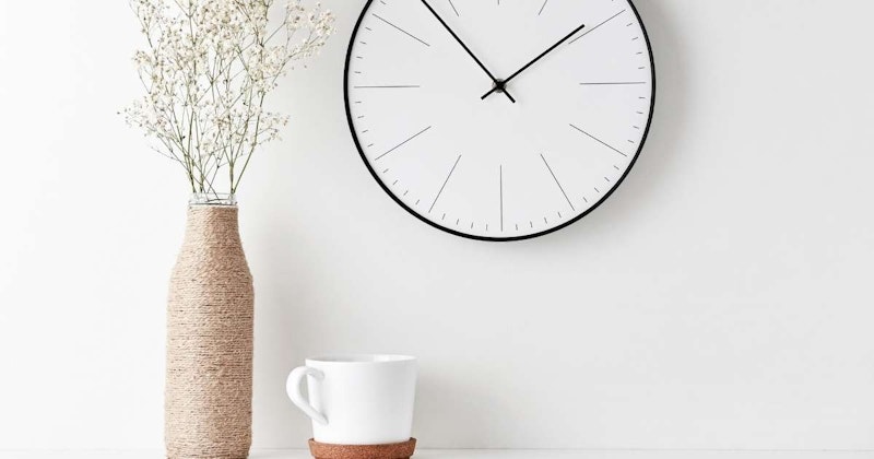 Bu resim, duvarda asılı, beyaz ibreleri olan siyah yüzlü bir saati göstermektedir. Saatin yüzünün ortasında iki siyah ibresi olan küçük bir daire vardır. Saatin sağında kulplu beyaz bir kupa, solunda ise içinde renkli çiçekler olan bir vazo yer almaktadır. Resmin sağ alt köşesinde bir ipin yakın çekimi yer almaktadır. Saatin etrafında beyaz bir bordür var gibi görünüyor ve arka plandaki duvar beyaza boyanmış. Saat resmin ana odak noktasıdır ve diğer unsurlar saatle hoş bir kontrast oluşturmaktadır. Genel olarak bu, merkezdeki duvarda klasik bir saatin yer aldığı huzurlu ve sakinleştirici bir görüntüdür.