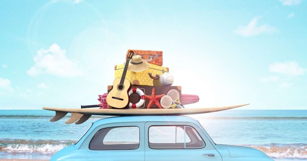 Bu görsel, tavanında bir sörf tahtası bulunan mavi bir minibüsü göstermektedir. Sörf tahtası açık mavi ve beyaz renkli bir desene sahip. Minibüsün yan tarafında, içinden parlak gökyüzünün görülebildiği bir pencere var. Minibüsün yanında, üzerinde bir gitar ve bir plaj topu bulunan bir yığın valiz vardır. Minibüsün yanındaki rafta bir denizyıldızı ve bir gitar var. Ayrıca gitara yaslanmış sarı bir bavul ve masanın üzerinde kırmızı bir denizyıldızı vardır. Bavulun üstünde siyah bantlı hasır bir şapka var.