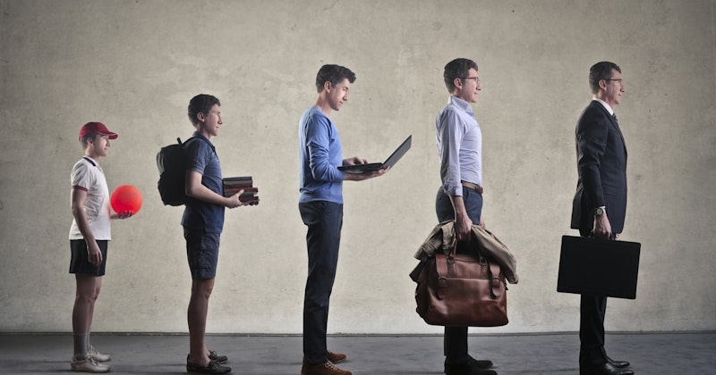 Bir elinde dizüstü bilgisayar, diğer elinde bir yığın kitap tutan bir adam sırada durmaktadır. Takım elbise giymekte ve bir evrak çantası taşımaktadır. Bir başka adam bir elinde kırmızı bir top, diğer elinde kırmızı bir balon tutarak yakınlarda durmaktadır. Onun arkasında bir kişi elinde bir tür çanta tutuyor ve daha geride biri kahverengi bir çanta ve siyah bir evrak çantası taşıyor. Tüm insanlar farklı pozlarda ve arka plan bulanık. Bu, kuyrukta bekleyen ve her biri kendi eşyalarını taşıyan insanlardan oluşan bir sahnedir.