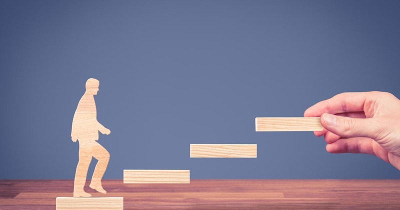 Bu resimde bir merdivenden yukarı tırmanan ahşap bir adam figürü görülmektedir. Beyaz bir gömlek ve kahverengi bir pantolon giymektedir ve elleriyle merdiven korkuluklarını tutmaktadır. Merdivenin tepesinde ahşap bir ayı figürü var. Ön plandaki masanın üzerinde, etrafta yüzen birkaç tahta blok var. Arka planda, ahşap bir yüzeyin yakın çekimi var. Ayrıca, muhtemelen merdivenleri çıkan figüre ait bir tırnağın yakın çekimi de var. Son olarak, görüntüde elinde bir tahta parçası tutan bir kişi görülebiliyor. Bu görüntü bir bütün olarak, birden fazla unsur içeren benzersiz ve karmaşık bir sahneyi yakalamaktadır.