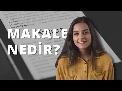 Kameraya gülümseyen bir kadının yüzünün yakın çekimi. Koyu renk gözleri ve hafif dalgalı, omuz hizasında saçları var. Yanakları hafif pembe ve dudakları hafif bir gülümsemeyle kıvrılmış. Gözleri parlak ve ifadesi neşeli. Üzerinde gri desenli harf ve sembollerden oluşan beyaz bir tişört vardır. Tişörtün yakası açık ve kumaşı hafifçe kırışmış. Kadın düz beyaz bir arka plana sahip aydınlık bir ortamda durmaktadır.