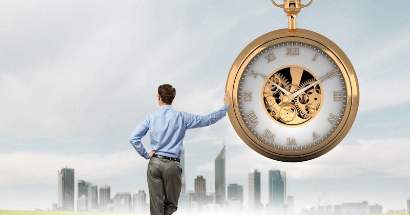 Mavi gömleği pantolonunun grisini tamamlayan bir adam saatin yanında durmaktadır. Sağ elini saate doğru kaldırmış, sol elini ise cebine sokmuş. Saat, iki siyah ibresi olan beyaz bir yüz ve arkasında karmaşık bir dişliler ağından oluşuyor. Resmin sağ alt köşesinde bir kupanın yakın çekimi görülmektedir. Adamın yüzü kameraya dönüktür ve sadece başının arkası görünmektedir. Saat, adam ve kupa açık gri duvarlı bir odada durmaktadır.