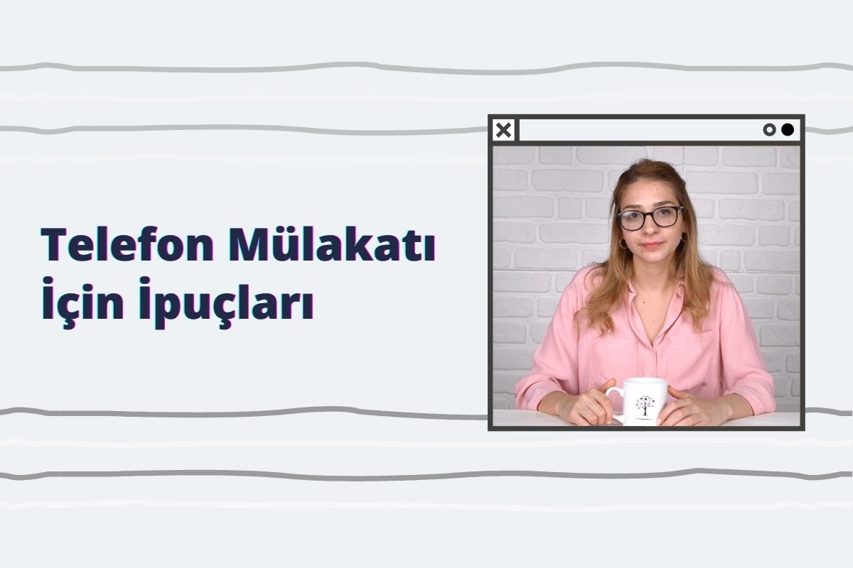 Bu resimde elinde beyaz bir kupa tutan, pembe gömlekli ve gözlüklü bir kadın görülüyor. Gülümsüyor ve rahat bir ortamda olduğu görülüyor. Kupayı göğsüne yakın tutuyor ve elleri kupanın üst kısmına yakın. Resmin arka planı beyaz bir duvar ve üzerinde siyah bir yazı var. Kadın dik duruyor ve ayaklarını hafifçe açmış. Dudakları hafifçe açık, bu da resme bir memnuniyet ifadesi katıyor. Gözleri dümdüz ileri bakıyor, odaklanma ve konsantrasyon izlenimi veriyor. Kupa açık tonda ve yan tarafında bazı ince desenler var.