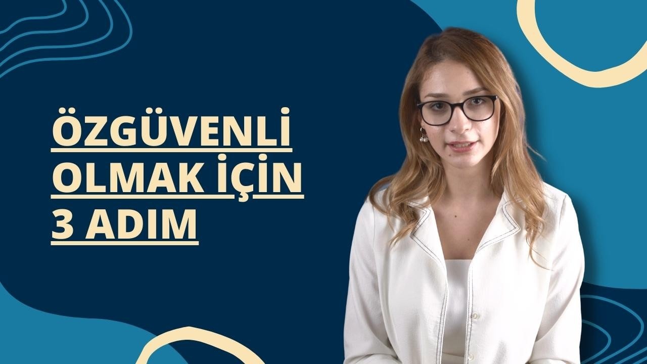 Gözlüklü ve beyaz gömlekli bir kadın mavi beyaz bir tabelanın önünde duruyor. Gözleri odaklanmış bir şekilde dümdüz karşıya bakıyor. Gözlükleri ince siyah çerçevelidir ve gömleğinin ön tarafında birkaç düğme vardır. Arkasındaki tabelada Hoş geldiniz yazan beyaz bir metin var. Solunda mavi beyaz girdaplı bir desen ve mavi beyaz logolu kavisli bir nesne var. Saçları hafif dağınık ve duruşu rahat. Odaklanmış ve düşünceli görünüyor.