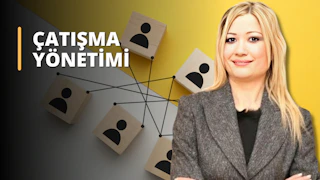 Bu görüntü bir Çatışma Yönetimi Eğitimi sınıfından. Sarı saçlı bir kadın grubun ortasında gülümsüyor ve etrafı ahşap bloklardan oluşan bir ağ ile çevrili. Bloklar, sınıfın birbirine bağlılığını simgeleyen kişi simgeleri ve yüzlerle süslenmiştir. Ayrıca, üzerinde kişi simgesi bulunan bir tabelanın yakın çekimi de görülebilmekte ve sınıf arasındaki bağlantı daha da vurgulanmaktadır. Bu görsel, Çatışma Yönetimi Eğitiminin interaktif ve işbirliğine dayalı bir öğrenme deneyimi sağladığı fikrini aktarmaktadır. Bu kurs sayesinde katılımcılar çatışmaları etkili bir şekilde yönetmeyi ve güçlü ilişkiler kurmayı öğrenebilirler.