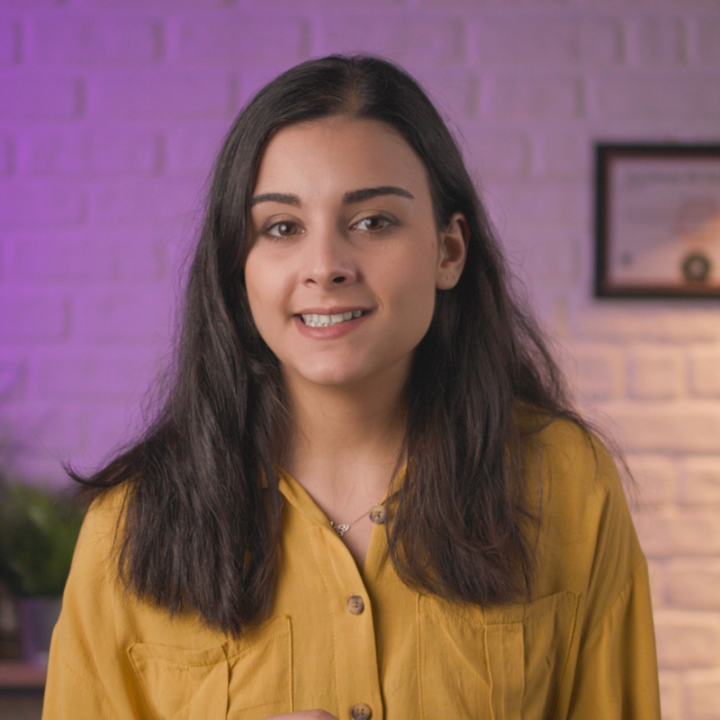 Sarı gömlekli bir kadın yeni işiyle ilgili konuşuyor